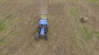 Saman balya ile traktör üzerinde çalışan adam