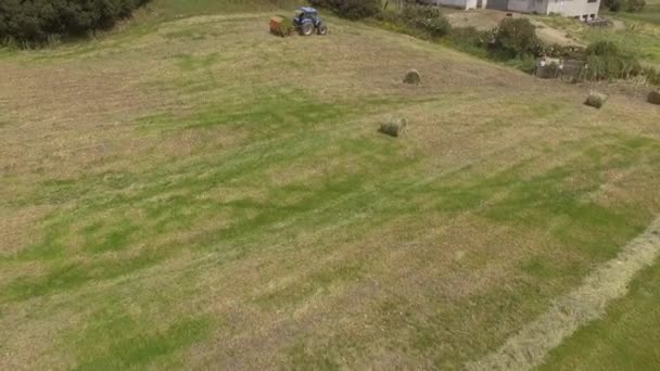 Oeil d'oiseau de l'homme au travail sur le tracteur avec presse à foin — Video