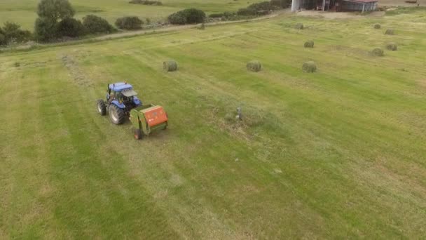 Bird eye of Man at work on the tractor with hay baler — Stock Video