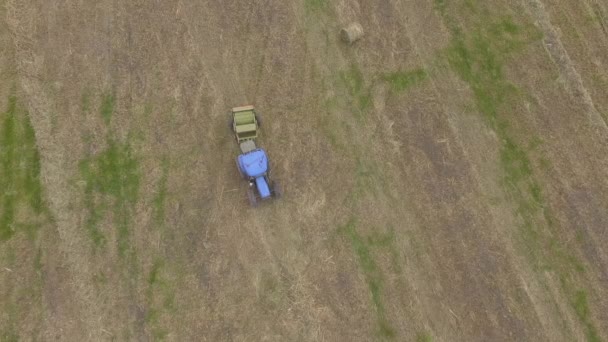 ptačí oko člověka při práci na traktoru s balerem na seno