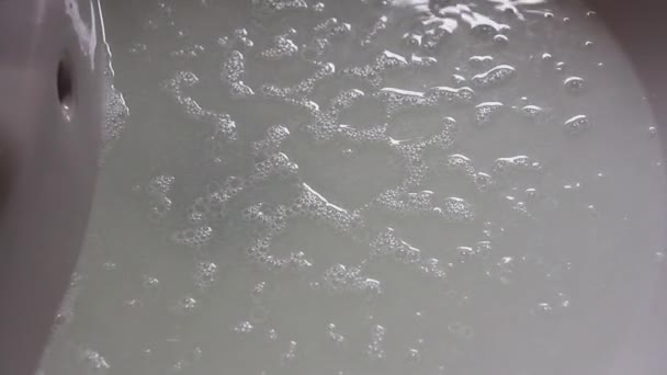 Voda vytékající z kohoutku v koupelně a dolů do výtoku, viděna pomalým pohybem — Stock video