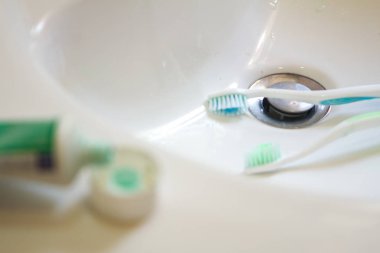 diş fırçası üzerine diş macunu sıkan eller ile kız ellerini ve yüzünü ve diş kişisel hijyen yıkama ile kişisel hijyen