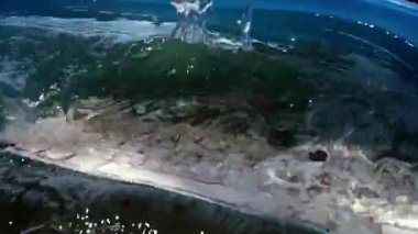 beyaz kablosuz bilgisayar klavyesi yavaş çekimde su püskürtme görünümü içine düşüyor