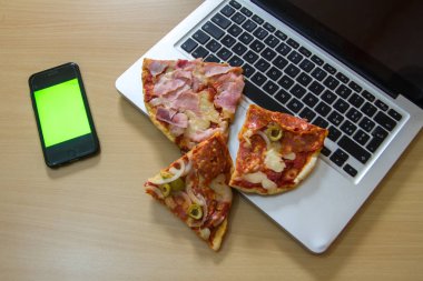 bir bilgisayar klavyesi üzerinde dilimlenmiş İtalyan pizza dolması