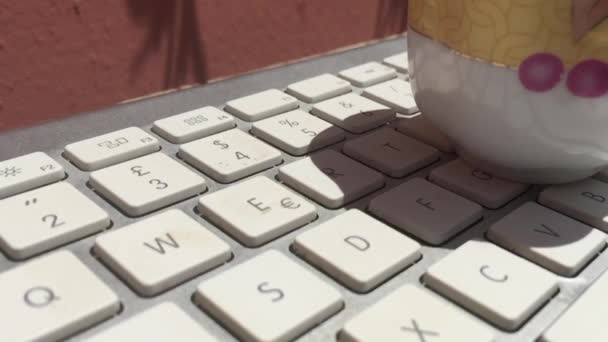 Taza de café derramado en un teclado portátil — Vídeo de stock