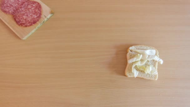 Préparation d'un sandwich savoureux aux ingrédients naturels sur une table en bois vue en stop motion — Video