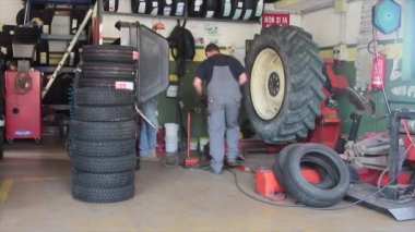 garajda kamyon ve araba lastiklerini değiştiren ve tamir eden iş yerinde lastik tamircisi
