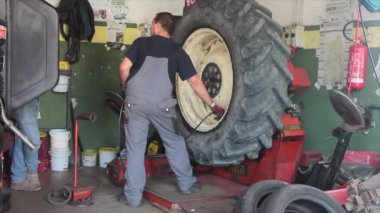 garajda kamyon ve araba lastiklerini değiştiren ve tamir eden iş yerinde lastik tamircisi