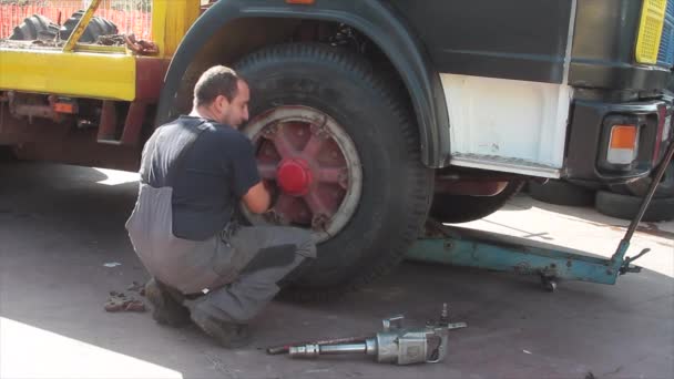 Ремонтник шин на работе, который меняет и ремонтирует грузовые и автомобильные шины в гараже — стоковое видео
