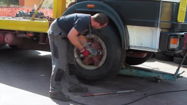 Tire repairer at work that changes and repairs truck and car tires in the garage — Stock Video