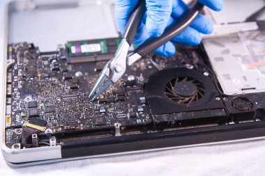 bir sabit disk sürücüsüne tek elle eldiven ve özel cımbızla sabitleme