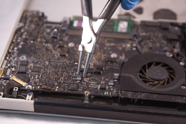 fixing a hard disk drive with one hand with gloves and a special tweezers