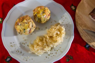 Tabakta lahana turşulu iki tokmak arka planda benek ve bir kupa bira ve Noel masa örtüsü.