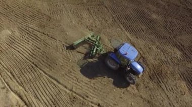 Mavi traktörün faaliyet halindeki 1havadan görüntüsü ektikten sonra toprağı eziyor