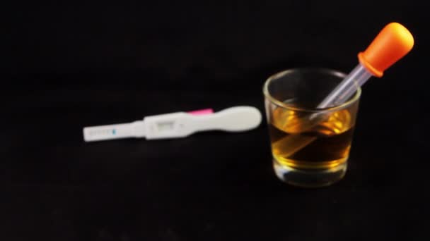 1close up de la prueba de embarazo con el vidrio con orina en el lado — Vídeos de Stock