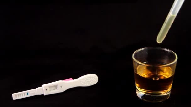 Gros plan du test de grossesse avec le verre avec de l'urine sur le côté — Video