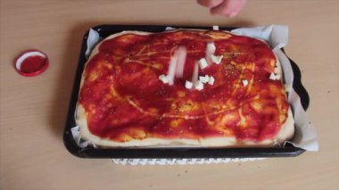 İtalyan mozzarella peyniri, ekşi hamurdan yapılmış yağan İtalyan pizzasının küplerine bölünmüş.