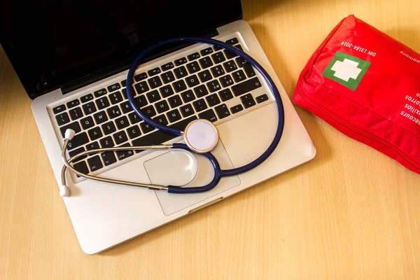 medical tools such as stethoscope, gloves and a mask resting on a computer keyboard as a symbol of the reparation of laptops and doctors with computers and medi kit