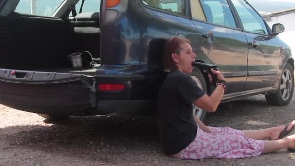 Жінка з пістолетом в руці вагається вчинити самогубство хотіла б стріляти в голову або рот, сидячи перед автомобілем — стокове відео