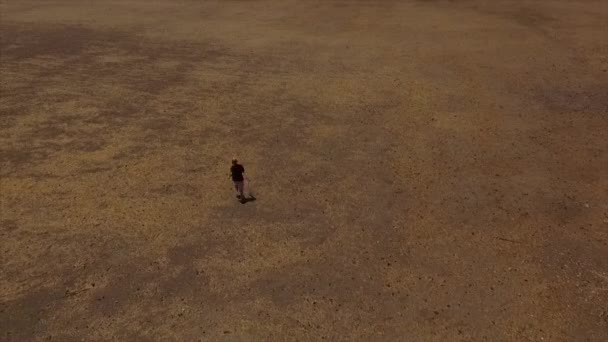 Luftaufnahme eines glücklichen Mädchens, das in einem trockenen Feld mit den Händen in den Himmel läuft, als Symbol der Freiheit — Stockvideo