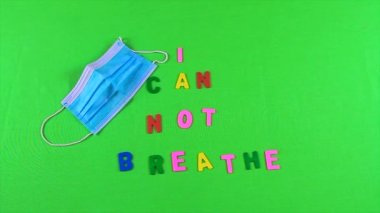 Kadının eli yeşil ekranda gergin bir şekilde tıbbi bir maskenin yanında nefes alamadığım ifadeyi oluşturan harfleri süpürüyor.