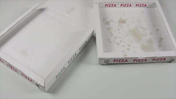 Hand eines Pizzakochs mit blauen Handschuhen legt sanft eine italienische Pizza auf den Pizzakarton neben eine leere — Stockvideo