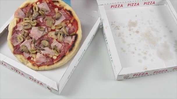 Ręka producenta pizzy, który bierze całą pizzę z tektury i kładzie kawałek pizzy i skórkę z pizzy na drugiej, pustej tekturze — Wideo stockowe