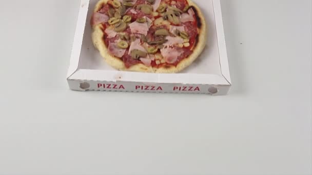 Mano de un chef de pizza con guantes que corta una pizza italiana entera en rebanadas en el cartón y la cierra suavemente lista para ser entregada o comida — Vídeo de stock