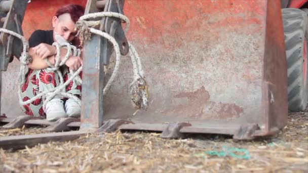 Kvinde kidnappet og voldtaget bundet med et reb og gagged med gaffatape i en spand gravemaskine, der forsøger at bryde fri, men kan ikke – Stock-video