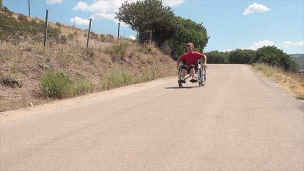 La vida cotidiana de una persona con discapacidad en una silla de ruedas que viaja por una carretera prestando atención a los coches — Vídeos de Stock