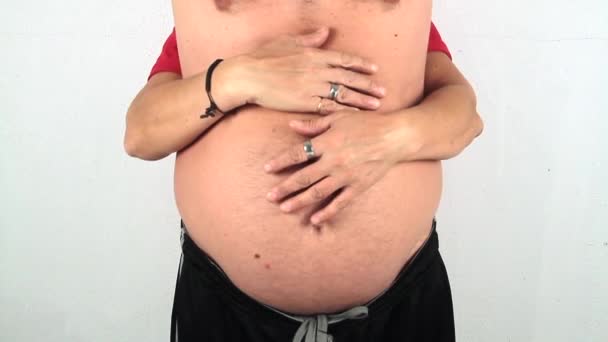 Hrnec břicho muž, který je jemně objat na břiše zezadu jeho ženou — Stock video