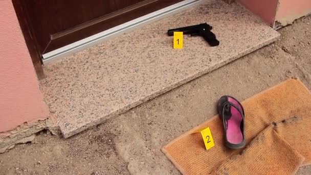 Dveře domu přilepené páskou z místa činu, hlupák husy ho podrobí soudnímu zabavení s pistolí na dolní vražedné zbrani očíslované žlutou kartou od detektiva CSI — Stock video
