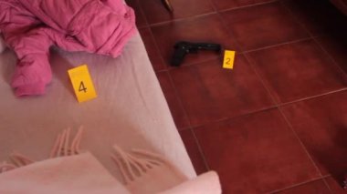 Motel beşiğinde kaçırılan çocuklar hakkındaki adli soruşturmalar. Deliller, ceket ve kukla gibi kanıtları olan dedektiflerin sarı kartlarıyla işaretlenmiş.