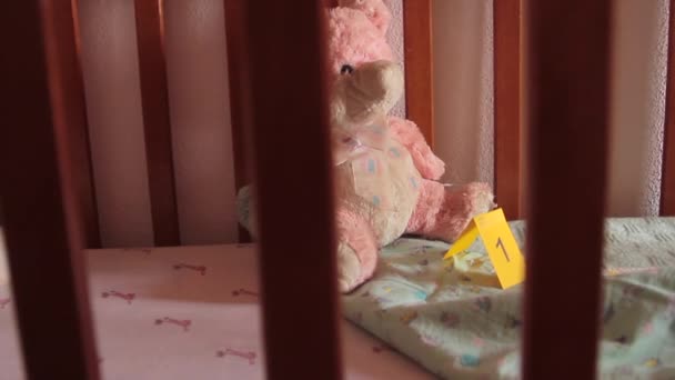 Melihat melalui langkan kayu tempat tidur bayi yang merupakan bukti penculikan bayi di mana detektif menempatkan bukti ditandai dengan kartu kuning — Stok Video