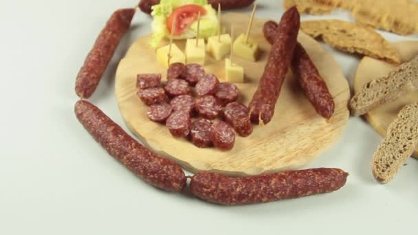 Schuifpui uitzicht op chef-koks handen serveren een typisch Zuid-Tiroolse snack bord als Tiroolse gerookte worst op een houten snijplank vergezeld van kaminwurz en paarl soort brood — Stockvideo