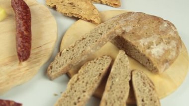 Şeflerin ellerinin tipik bir Güney Tirol aperatifi servis edişinin kaygan görüntüsü Tirol füme sosisi gibi tahta kesme tahtasının üzerinde kaminwurz ve paarl tipi ekmek eşliğinde.