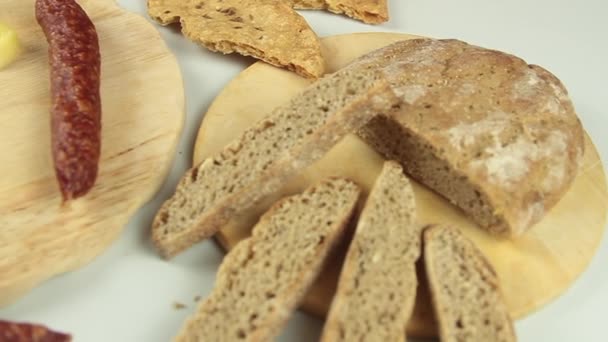 Posuvnější pohled na kuchařské ruce servírující typickou jihotyrolskou svačinku, jako je tyrolská uzená klobása na dřevěné řezací desce doprovázené kaminwurzem a chlebem typu paarl — Stock video