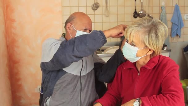 Ηλικιωμένο ζευγάρι στο σπίτι που βγάζει την προστατευτική μάσκα και φιλάει με αγάπη — Αρχείο Βίντεο