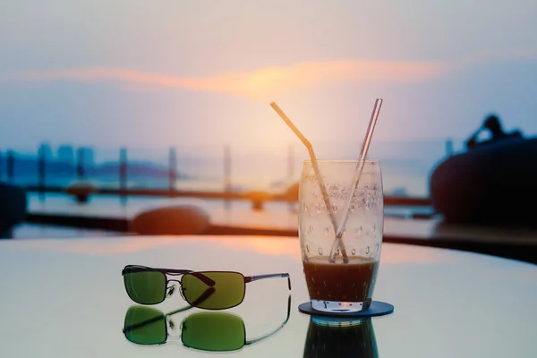 Lifestyle in restaurant with sunglasses and coffee cup on sunrise sky summer season