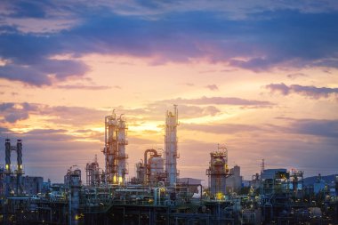 Petrol ve gaz rafineri sanayi veya Petrokimya sanayi tesisi günbatımı gökyüzü arka plan üzerinde imalatı