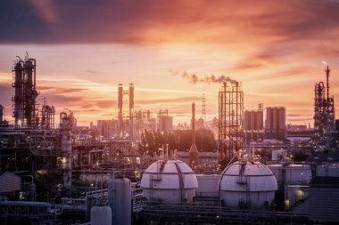 Gaz depolama küre tankları petrokimya endüstrisi veya akşam petrol ve doğal gaz rafineri tesisi, petrol sanayi tesisi ile gaz sütun ve duman yığın üretim günbatımı üzerinde gökyüzü arka plan