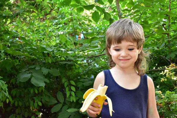 cute little boy eating banana