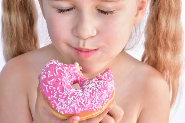 Klein Meisje Eet Een Roze Donut — Stockfoto