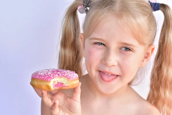 Niña Come Una Rosquilla Rosada —  Fotos de Stock