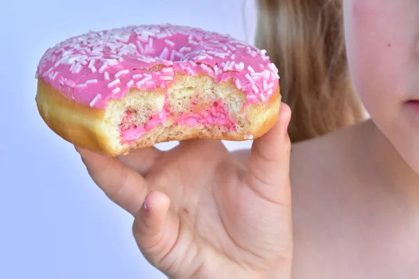 Klein Meisje Eet Een Roze Donut — Stockfoto