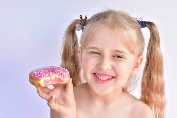 Klein Meisje Eet Een Roze Donut — Stockfoto