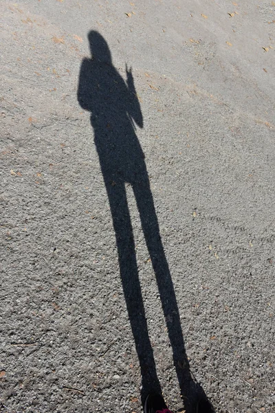沥青路面上一个人的影子 — 图库照片
