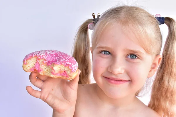 Klein Meisje Eet Een Roze Donut — Stockfoto