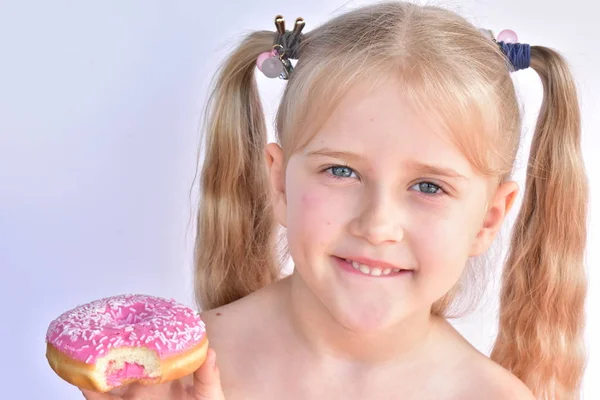 Klein Meisje Eet Een Roze Donut — Stockfoto