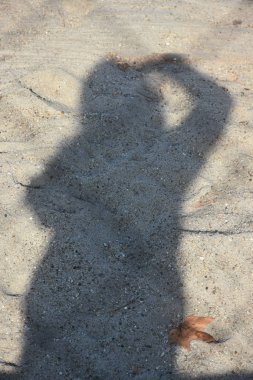 Asfaltta bir adamın gölgesi,